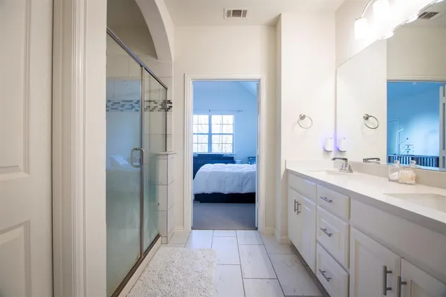 a en suite bathroom with a shower sink and mirror