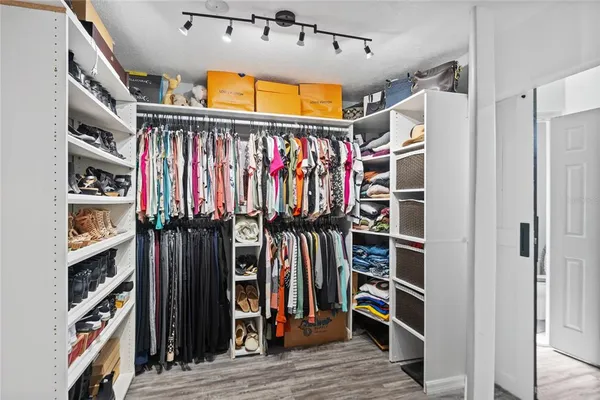 a view of walk in closet with clothes and shoes