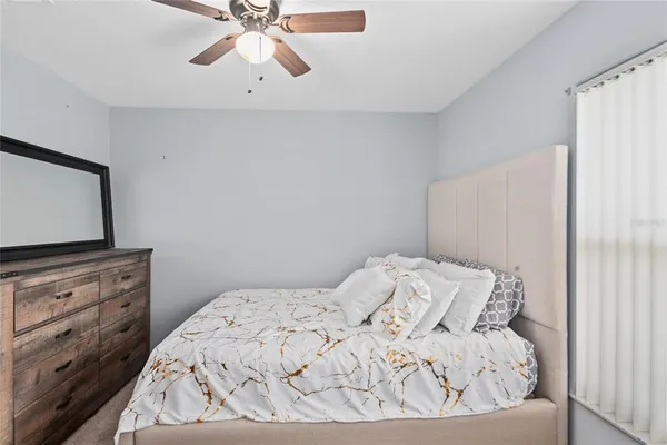 a bedroom with a bed and a flat tv screen on dresser