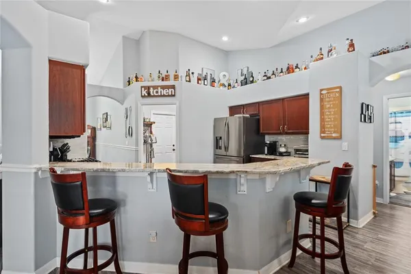a kitchen with stainless steel appliances a stove top oven table and chairs