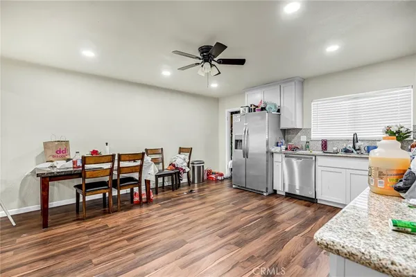 a kitchen with stainless steel appliances granite countertop a refrigerator a stove and a wooden floors