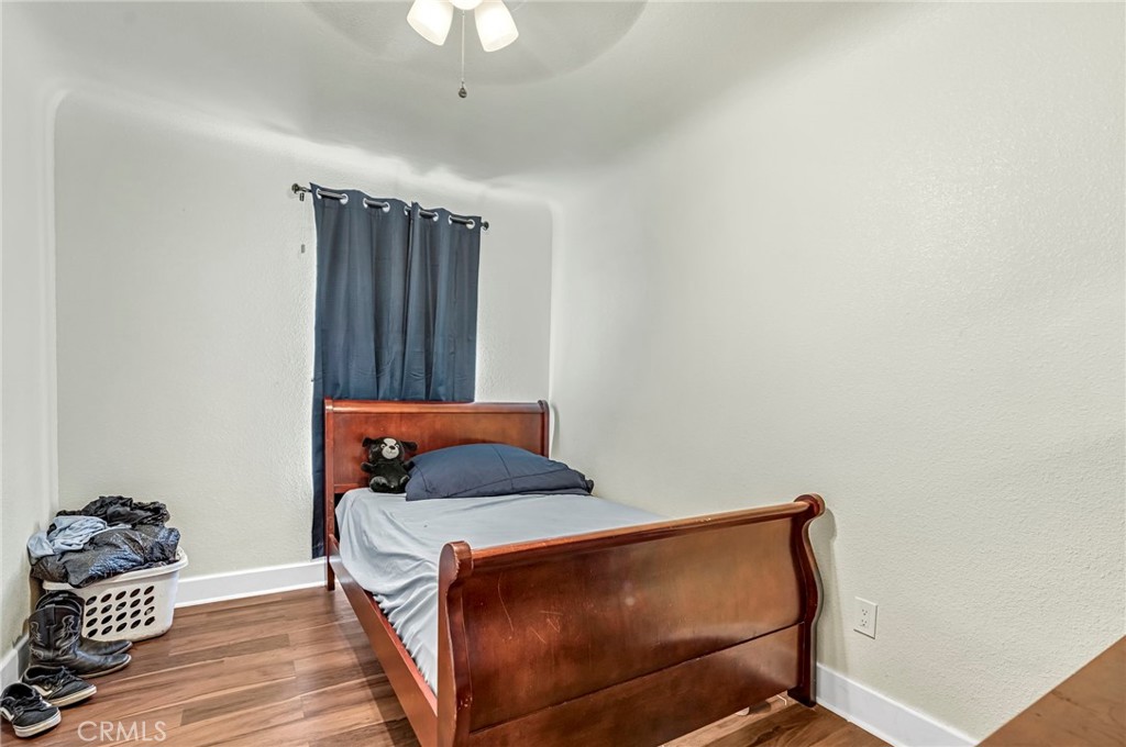 24110 Ave 14 Madera, CA 93637 - Photo 28 of 43 a bedroom with a bed and wooden floor