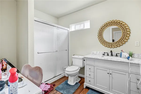 a bathroom with a toilet sink vanity and mirror
