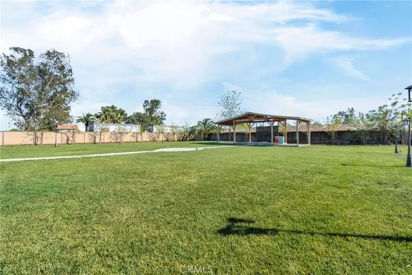 a view of a green field with house in the background