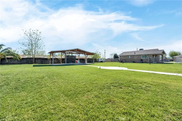 a view of a house with a big yard and large trees