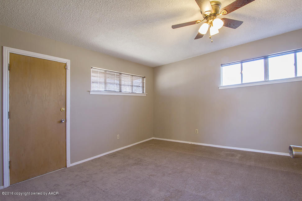 4818 Camp Lane Amarillo, TX 79110 - Photo 25 of 32 an empty room with windows and fan