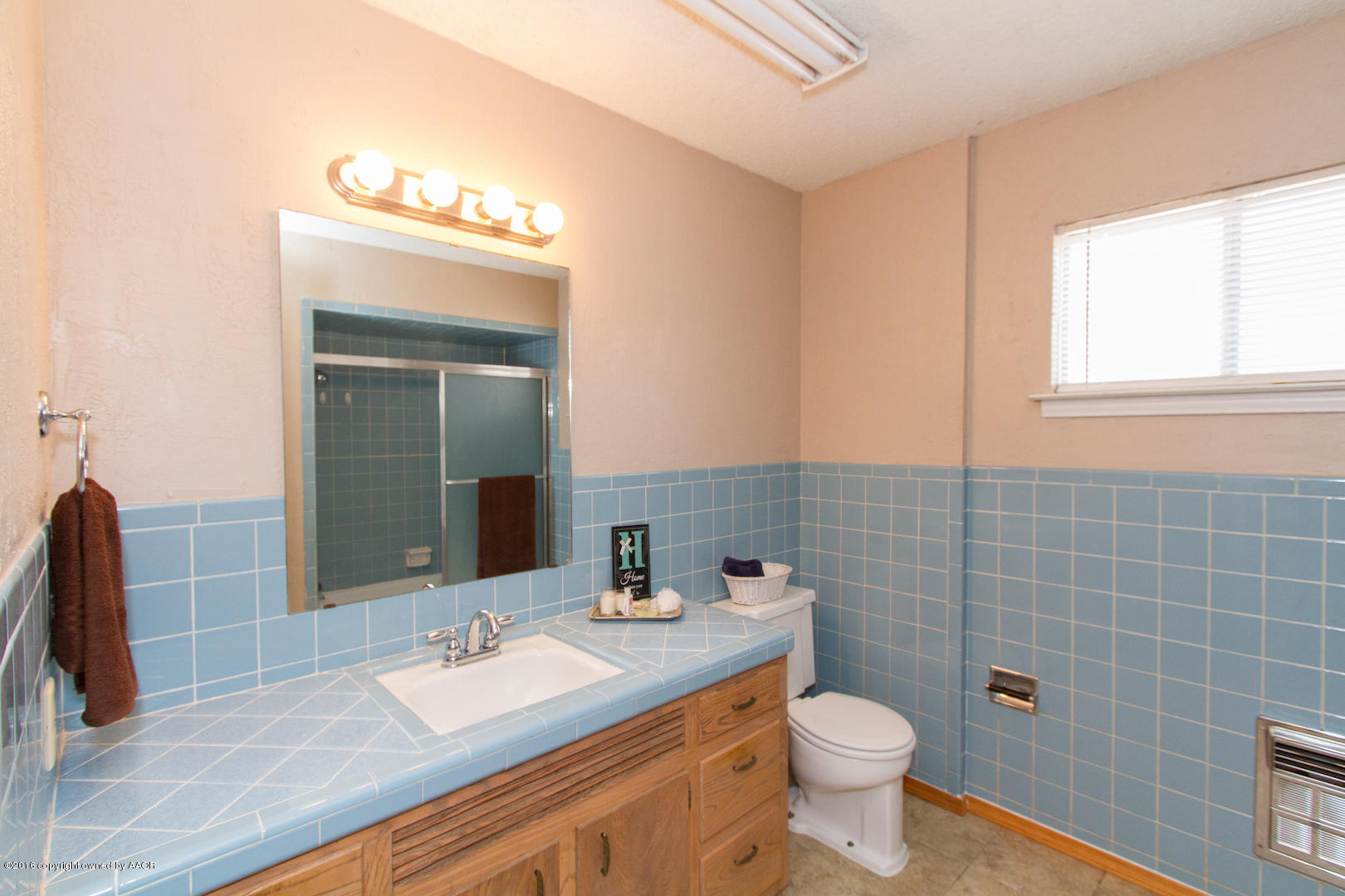 4818 Camp Lane Amarillo, TX 79110 - Photo 28 of 32 a bathroom with a granite countertop toilet a sink a mirror and a window