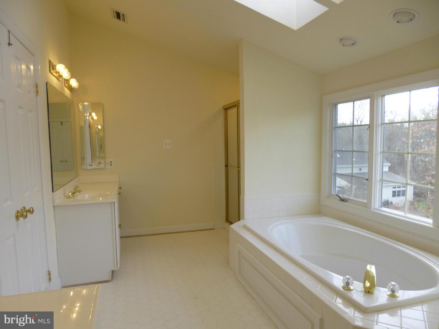 8837 Herons Flight Laurel, MD 20723 - Photo 16 of 29 a bathroom with a bathtub and a shower