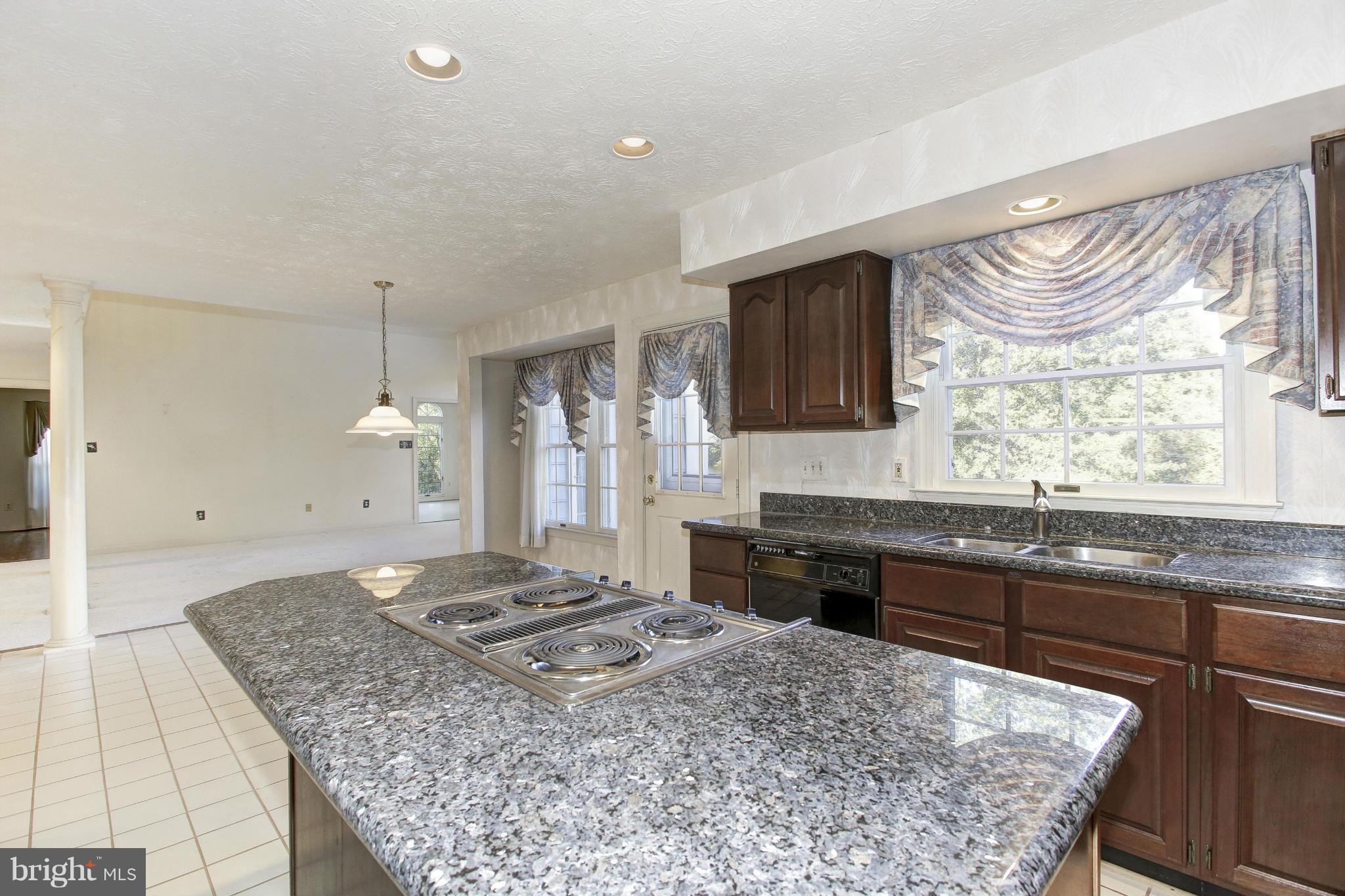 8837 Herons Flight Laurel, MD 20723 - Photo 9 of 29 a large kitchen with kitchen island granite countertop a sink and a stove