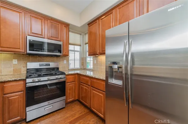 a kitchen with granite countertop stainless steel appliances and wooden cabinets