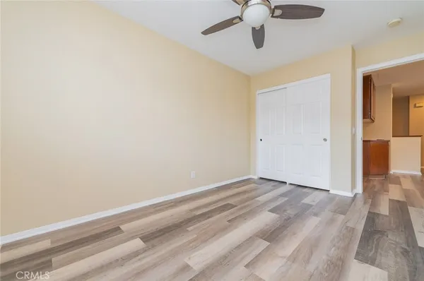an empty room with a ceiling fan and carpet