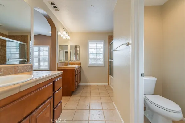 a bathroom with a granite countertop sink a toilet mirror and a bathtub