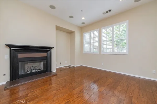 a view of an empty room with a fireplace and a window