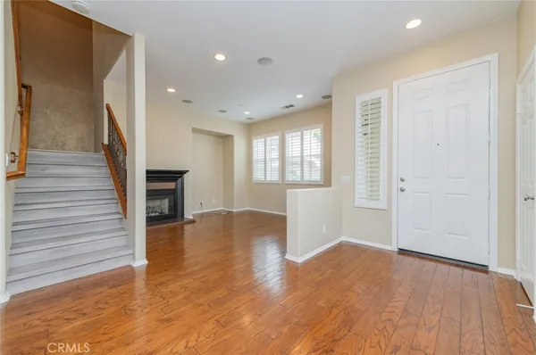 an empty room with wooden floor and fireplace