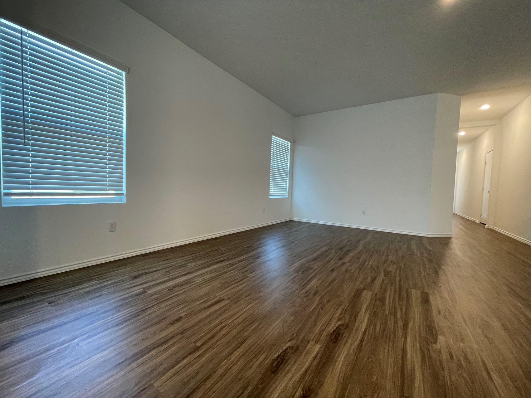 1625 Woolsey Way Leander, TX 78641 - Photo 6 of 17 Spacious room featuring wood-look flooring, white walls, and a window with blinds