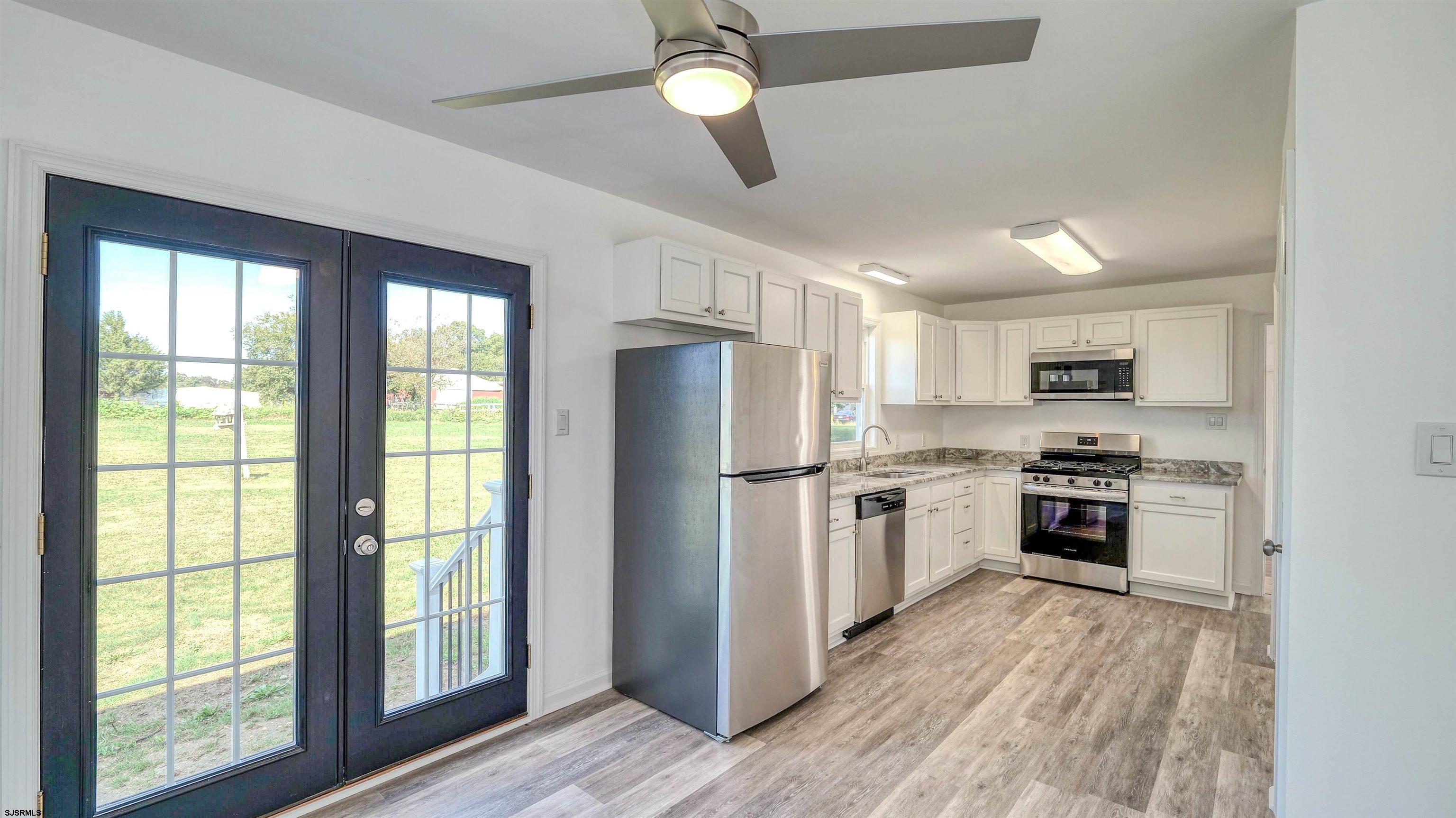 1510 East Wheat Road Vineland, NJ 08360 - Photo 7 of 26 a kitchen with stainless steel appliances granite countertop a stove top oven a refrigerator a sink and dishwasher with wooden floor