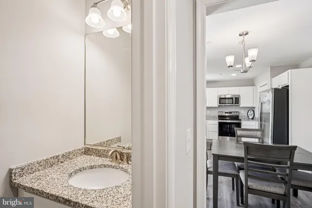 a kitchen with kitchen island granite countertop a sink cabinets and stainless steel appliances