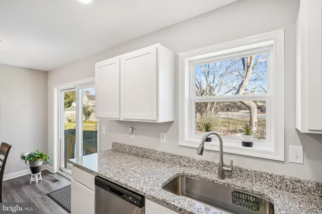 a kitchen with stainless steel appliances granite countertop a sink a granite counter tops and a window