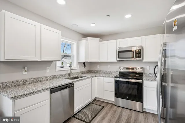 a kitchen with cabinets stainless steel appliances a sink and a counter space