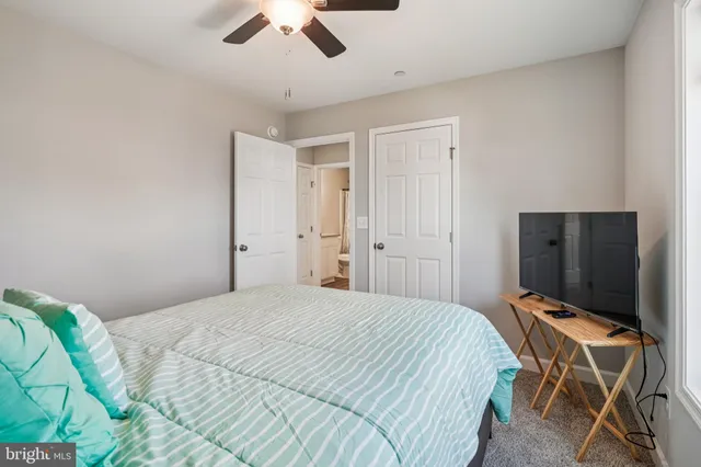 a bedroom with a bed and ceiling fan