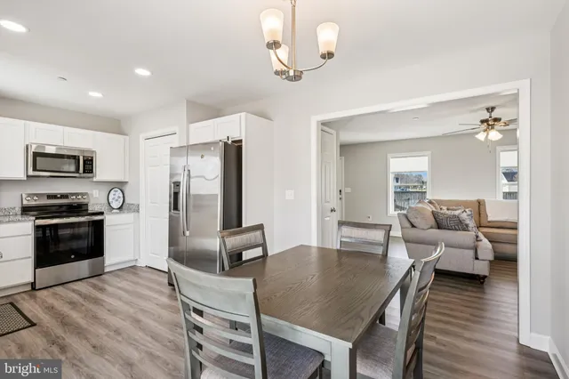 a living room with furniture dining table and stainless steel appliances