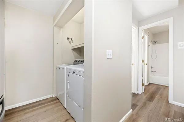 a view of a hallway with wooden floor and closet
