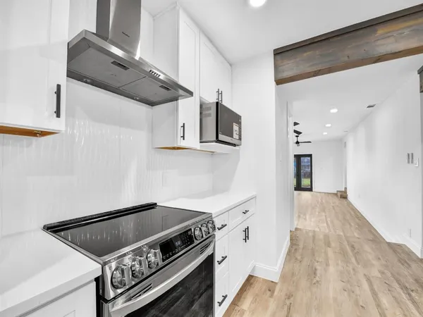a kitchen with a stove and a wooden floor