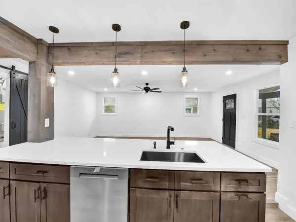 a kitchen with a sink a refrigerator and cabinets