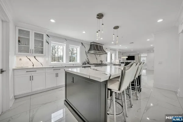 a large kitchen with kitchen island granite countertop lots of counter space and a sink