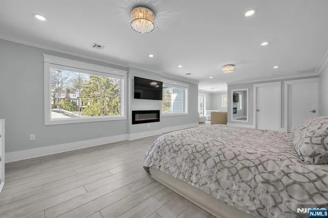 a spacious bedroom with a bed and a flat screen tv