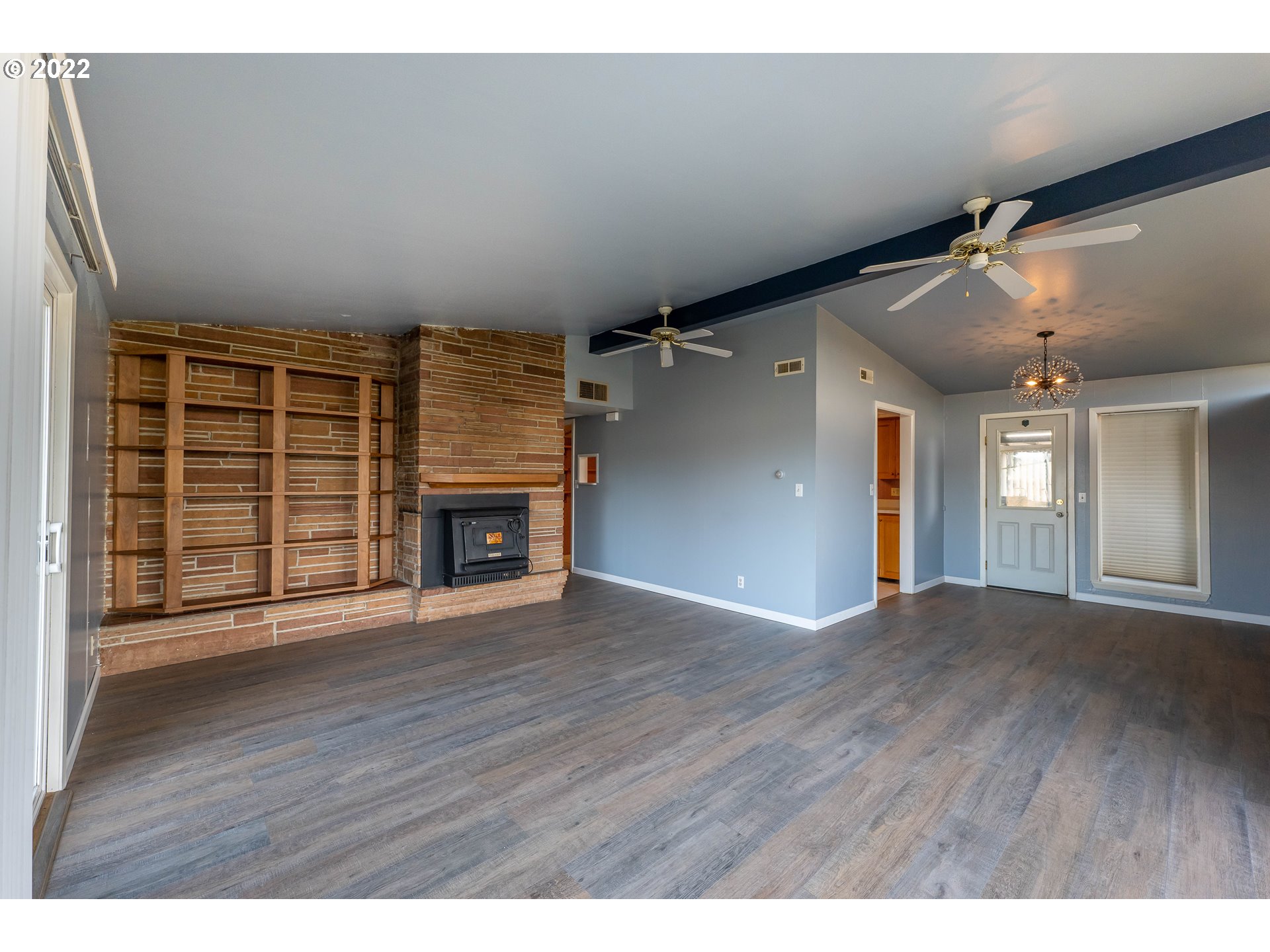 643 South State Street Sutherlin, OR 97479 - Photo 4 of 32 a view of an empty room with wooden floor fireplace and a window