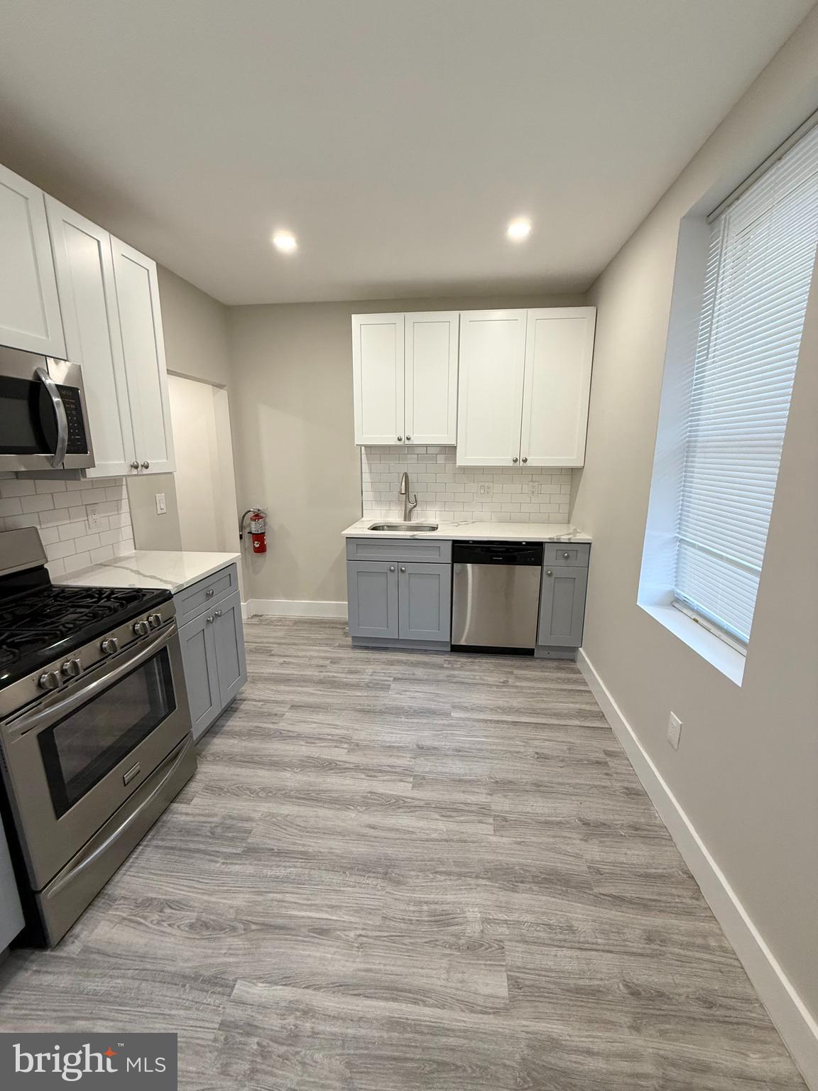 a large kitchen with stainless steel appliances granite countertop a stove a sink and a refrigerator