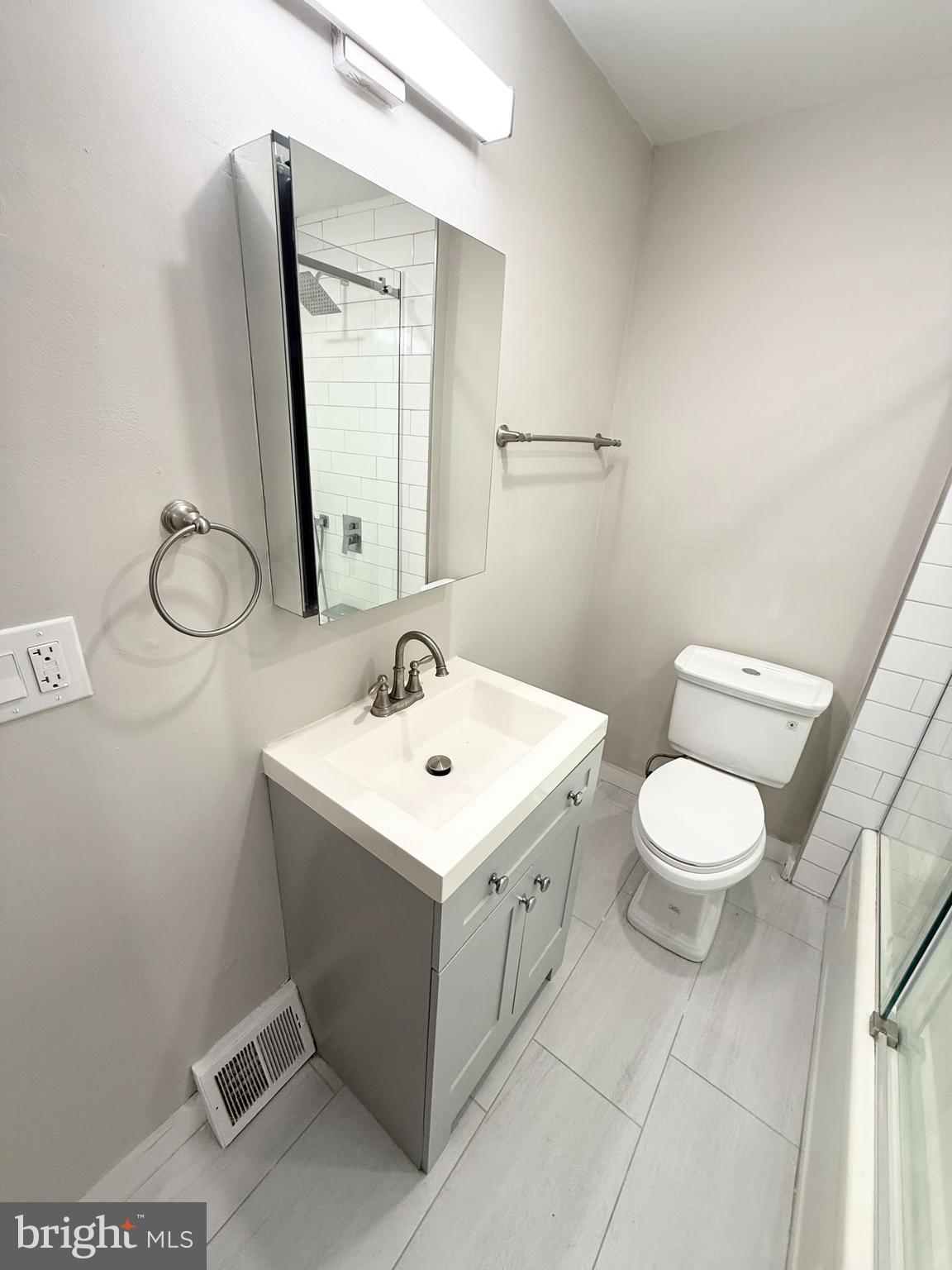 714 West Ritner Street, Unit 1 Philadelphia, PA 19148 - Photo 6 of 9 a bathroom with a toilet a sink and mirror