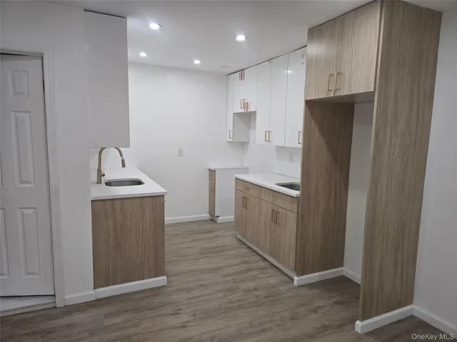 a kitchen with white cabinets sink and refrigerator