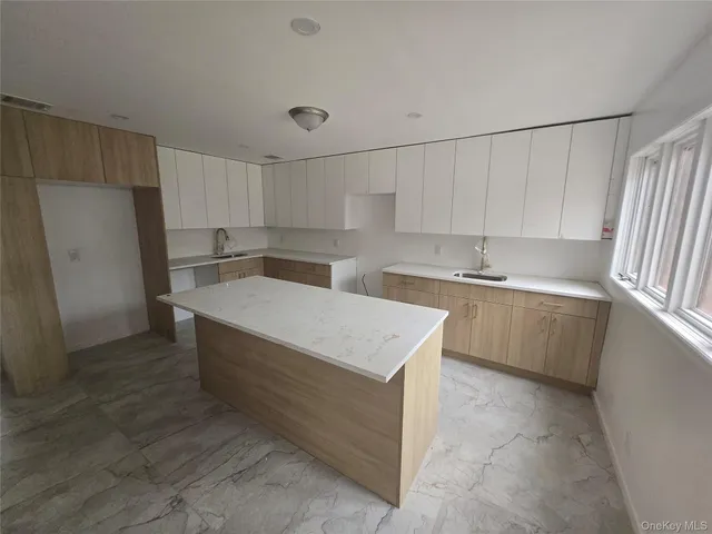 a kitchen with a cabinets a sink a counter and a refrigerator