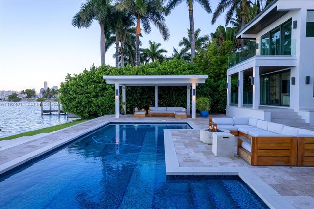 a view of a house with pool and sitting area