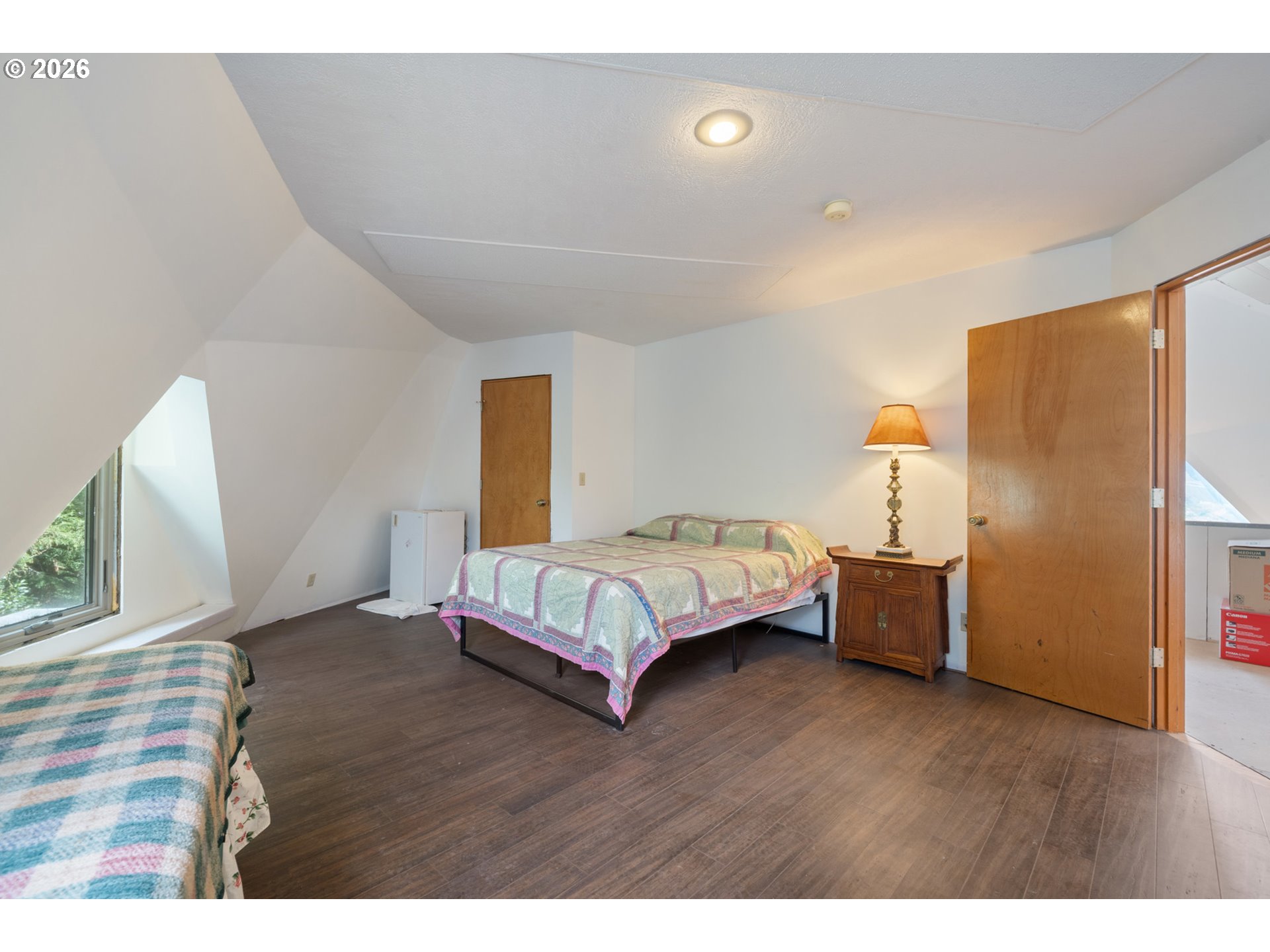 2500 Whiskey Creek Road Tillamook, OR 97141 - Photo 21 of 46 a bedroom with a bed and wooden floor