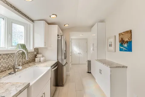 a kitchen with stainless steel appliances granite countertop a refrigerator a stove and a sink