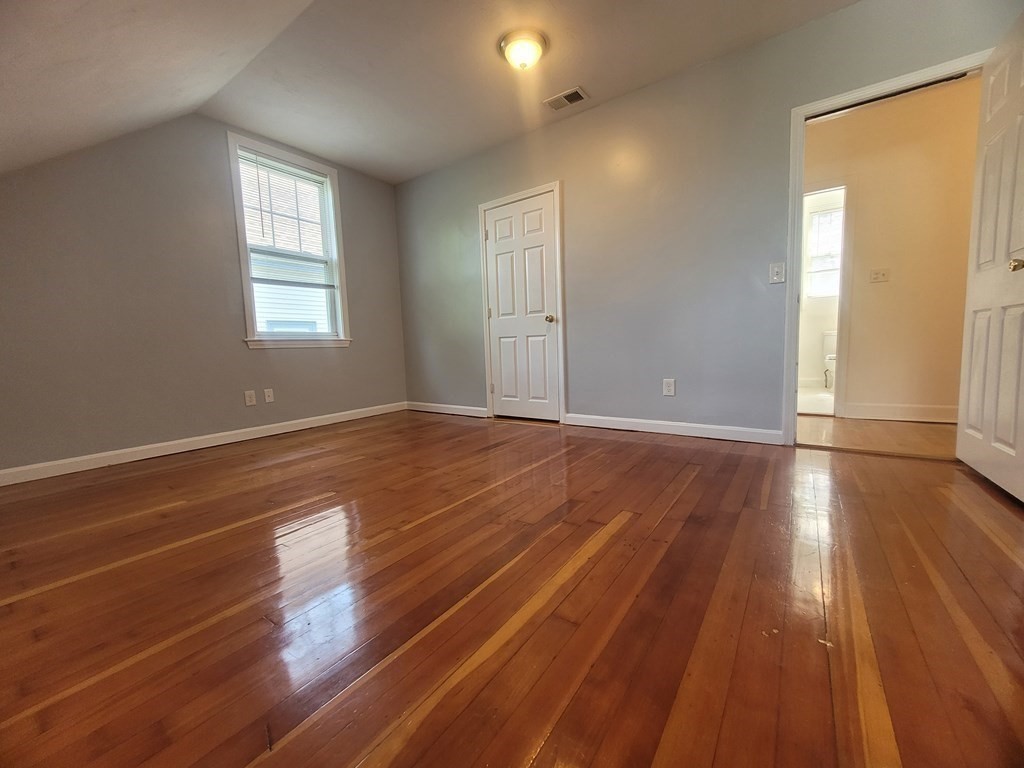 32 Cedar Street, Unit L Boston, MA 02126 - Photo 11 of 18 wooden floor in an empty room with a window