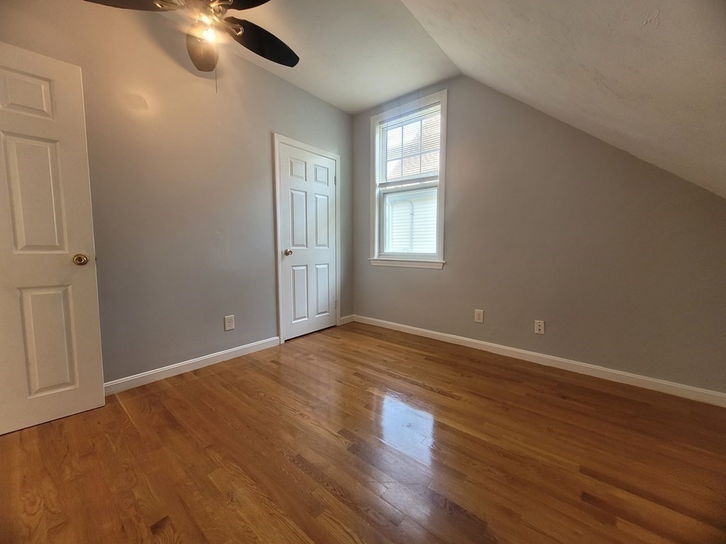 32 Cedar Street, Unit L Boston, MA 02126 - Photo 12 of 18 a view of an empty room with wooden floor and a window