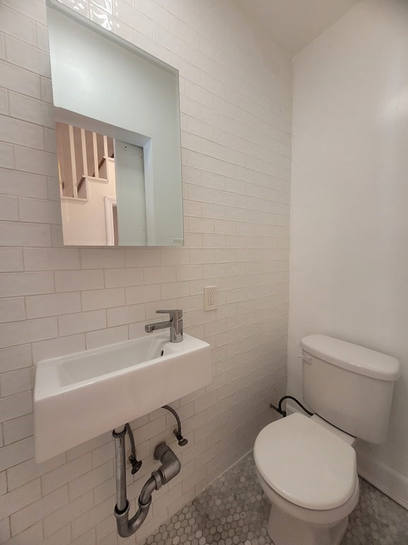 32 Cedar Street, Unit L Boston, MA 02126 - Photo 15 of 18 a bathroom with a toilet a sink and mirror