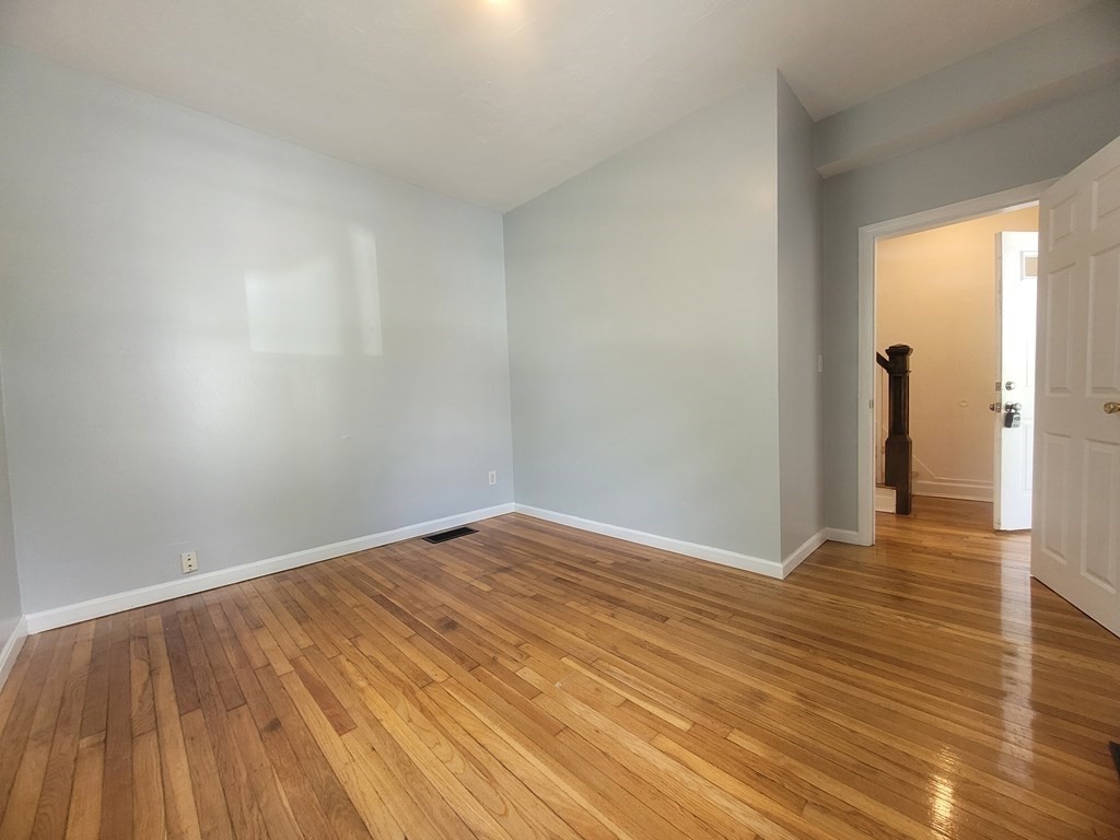 32 Cedar Street, Unit L Boston, MA 02126 - Photo 16 of 18 a view of an empty room and wooden floor