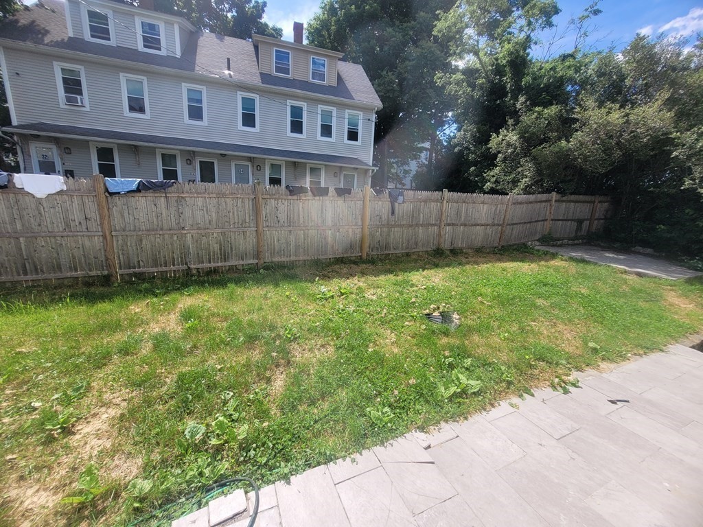32 Cedar Street, Unit L Boston, MA 02126 - Photo 18 of 18 a view of a house with a yard and a large tree