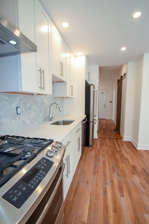 32 Cedar Street, Unit L Boston, MA 02126 - Photo 2 of 18 a kitchen with stainless steel appliances granite countertop a stove and a refrigerator