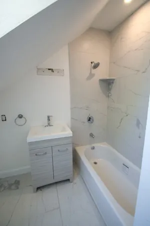 a bathroom with a bathtub sink and mirror