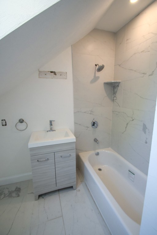 32 Cedar Street, Unit L Boston, MA 02126 - Photo 6 of 18 a bathroom with a bathtub sink and mirror