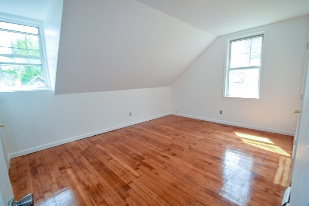 32 Cedar Street, Unit L Boston, MA 02126 - Photo 9 of 18 an empty room with wooden floor and windows