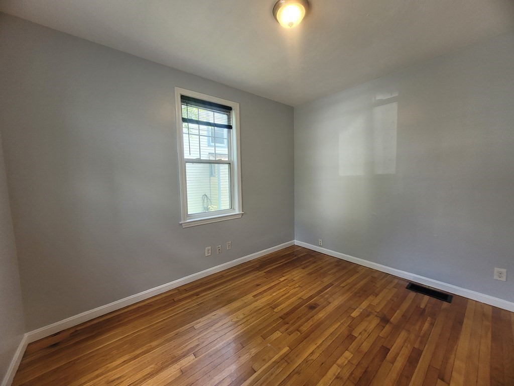 32 Cedar Street, Unit L Boston, MA 02126 - Photo 10 of 18 wooden floor in an empty room with a window