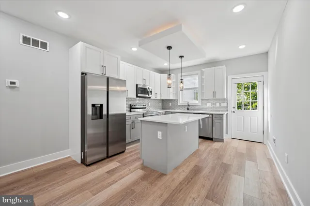 a kitchen with a refrigerator a sink and cabinets