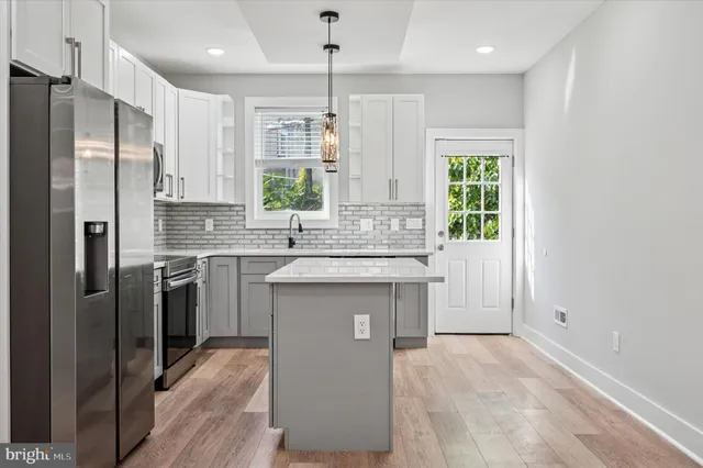 a kitchen with stainless steel appliances granite countertop a refrigerator a sink and a stove